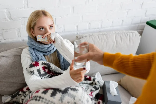 Homme verre avec de l'eau à la petite amie malade tenant blister paquet avec des pilules — Photo de stock