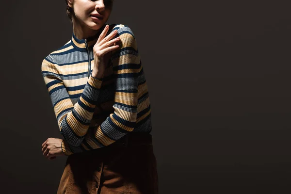 Cropped view of young woman in stylish autumnal outfit posing on black — Stock Photo