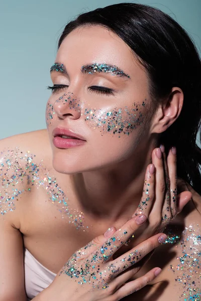 Vue grand angle de la jeune femme avec des paillettes sur le visage et le corps isolé sur le gris — Photo de stock