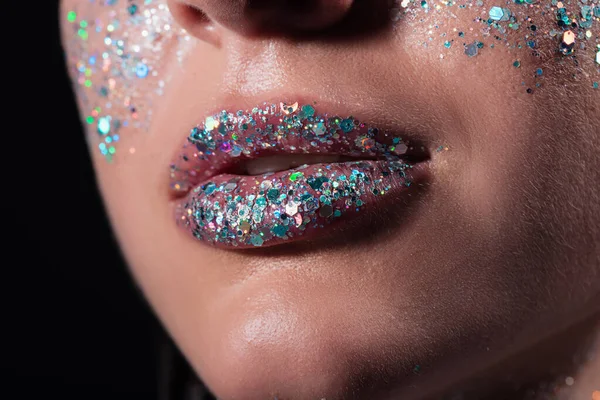 Vista cortada de mulher jovem com faísca glitter em lábios isolados em preto — Fotografia de Stock