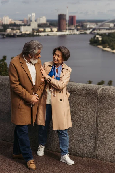 Volle Länge der glücklichen Seniorin, die bärtigen Ehemann in der Nähe des Flusses betrachtet — Stockfoto