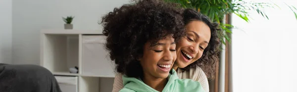 Happy african american preteen girl and curly mother looking down, banner — Stock Photo