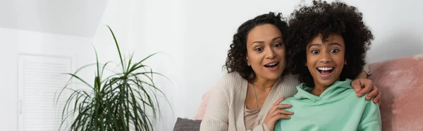 Heureux afro-américain mère étreignant excité fille préadolescente, bannière — Photo de stock