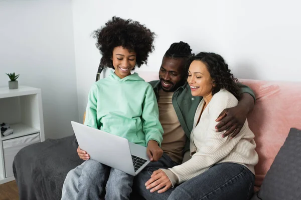 Allegra famiglia afroamericana che guarda film commedia sul computer portatile in soggiorno — Foto stock