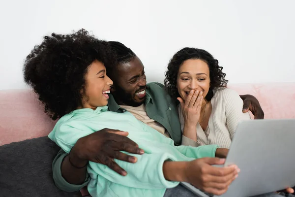 Positive african american family watching comedy movie on laptop in living room — Stock Photo