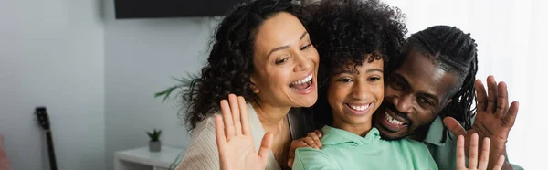 Allegra famiglia afro-americana che sorride e sventola le mani a casa, striscione — Foto stock