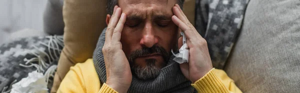 Draufsicht auf kranken Mann mit geschlossenem Liegen auf Couch und Berührung des Kopfes bei Kopfschmerzen, Banner — Stockfoto