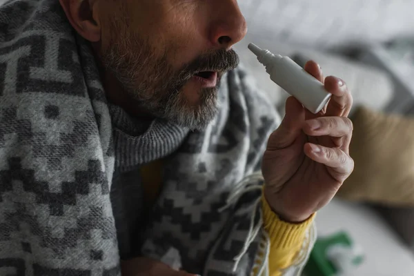 Vista recortada del hombre enfermo con rinitis usando aerosol nasal - foto de stock