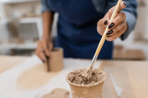 Vista ritagliata di donna afro-americana tenendo focalizzato shaper argilla — Foto stock