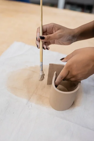 Vista cortada de mulher afro-americana segurando shaper enquanto modelando argila — Fotografia de Stock