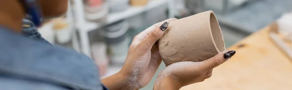 Vista parziale della donna afro-americana stampaggio tazza di argilla in mano, banner — Foto stock