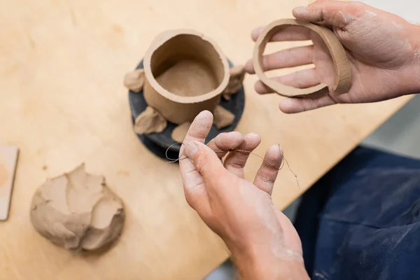 Vista dall'alto dell'uomo che tiene la lenza e l'argilla in studio di ceramica — Foto stock