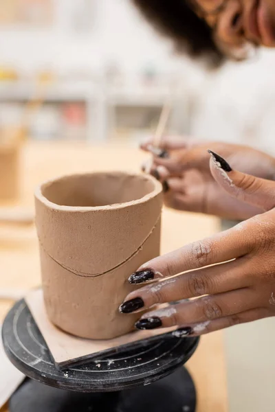 Vista cortada de artesã afro-americana fazendo escultura de barro em oficina — Fotografia de Stock