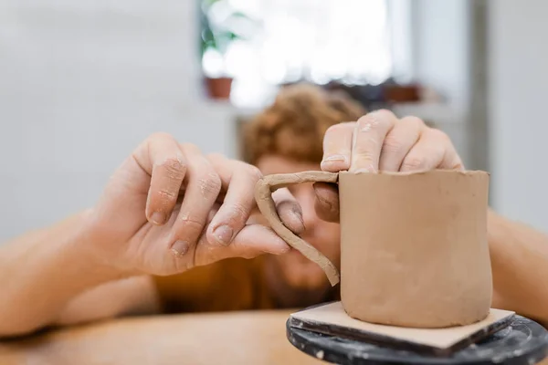 Blurred artisan making clay cup in pottery studio — Stock Photo