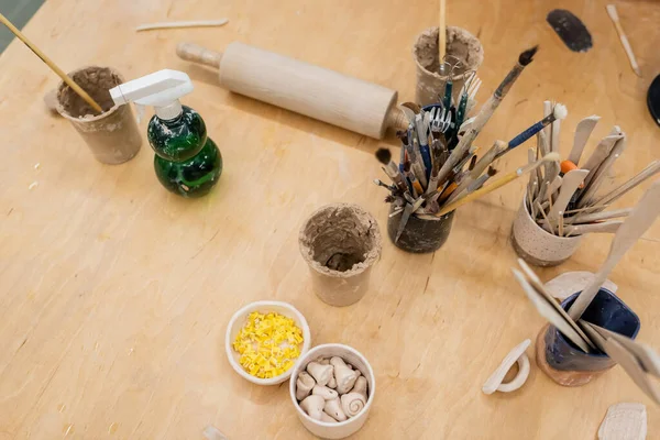 Vue de dessus des outils de poterie et pulvérisateur d'eau en atelier — Photo de stock