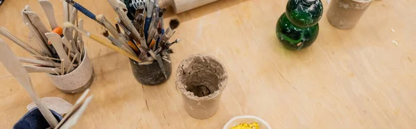 Top view of clay and pottery tools on table in workshop, banner — Stock Photo