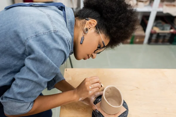 Vue latérale de l'artisan afro-américain formant des produits céramiques dans un atelier de poterie — Photo de stock