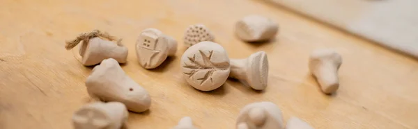 Vue rapprochée des sculptures en argile sur table en atelier de poterie, bannière — Photo de stock