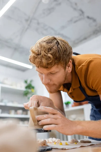 Rotschopf-Handwerker in Schürze formt Keramiktasse in Töpferei — Stockfoto