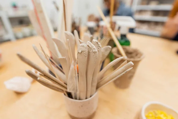 Utensili in ceramica sul tavolo in laboratorio di ceramica sfocata — Foto stock