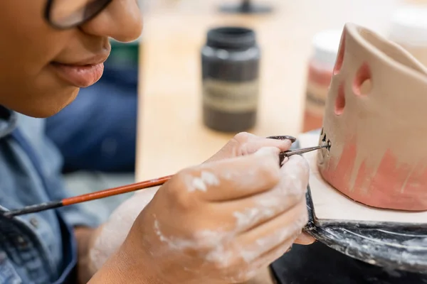 Ausgeschnittene Ansicht der afrikanisch-amerikanischen Frauenmalerei auf Tonskulptur im Töpferatelier — Stockfoto