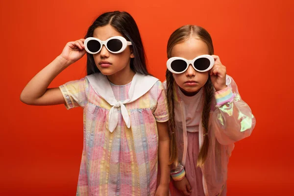 Mädchen mit ernstem Gesichtsausdruck und Sonnenbrille in Orange — Stockfoto