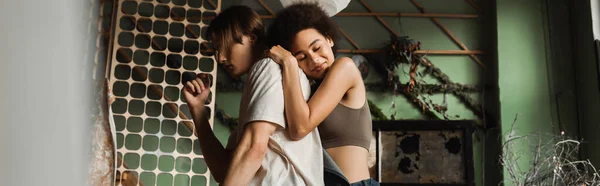 Smiling african american woman with closed eyes leaning on boyfriend in art studio, banner — Stock Photo