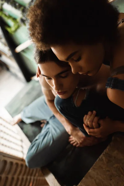 High angle view of young multiethnic artists with closed eyes holding hands in art studio — Stock Photo