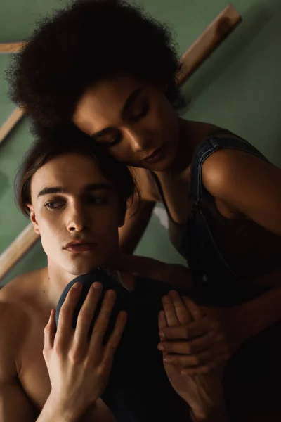 Young interracial couple in love embracing in art workshop — Stock Photo