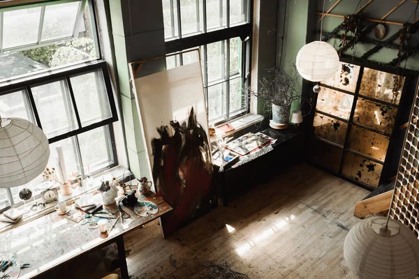 High angle view of spacious workshop with large windows and art tools on windowsills under sphere chandeliers — Stock Photo