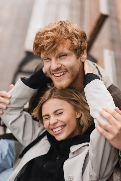 Alto ángulo vista de alegre joven mujer abrazando sonriente pelirroja hombre - foto de stock