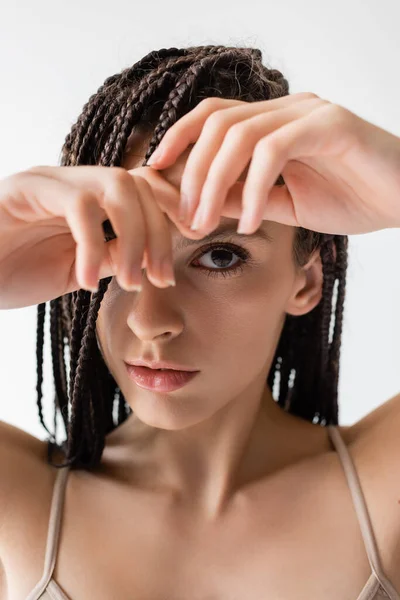 Portrait de jeune femme avec des tresses regardant la caméra isolée sur gris — Photo de stock