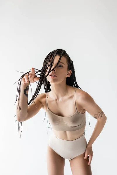 Fit woman in underwear pointing with finger at camera isolated on grey — Stock Photo