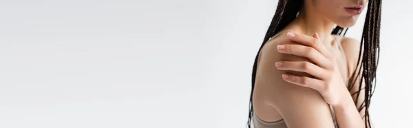 Cropped view of woman with braids touching shoulder isolated on grey, banner — Stock Photo