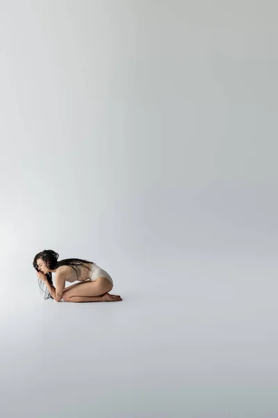 Side view of slim model in underwear posing on grey background — Stock Photo