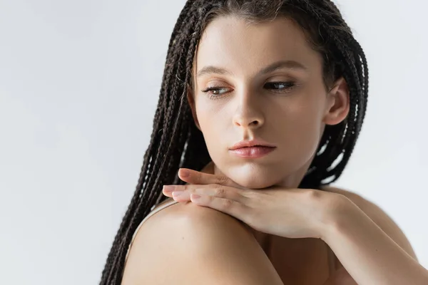 Retrato de mulher morena com tranças olhando para longe isolado em cinza — Fotografia de Stock