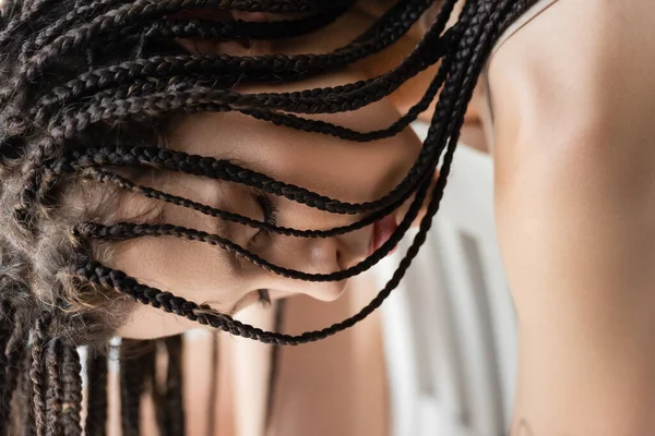 Молода жінка з косами позує із закритими очима ізольовано на сірому — стокове фото
