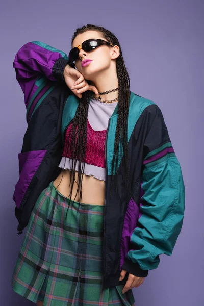 Trendy woman in vintage plaid skirt and sports jacket isolated on purple — Stock Photo