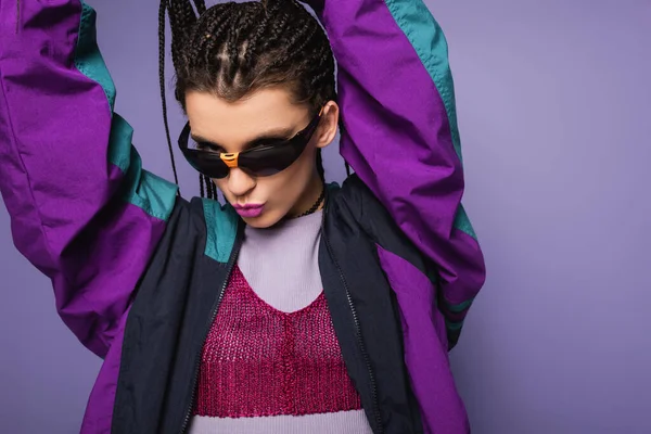 Brunette woman in nineties style attire pouting lips isolated on purple — Stock Photo