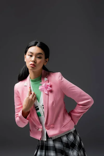 Femme asiatique élégante en veste rose posant isolé sur gris — Photo de stock