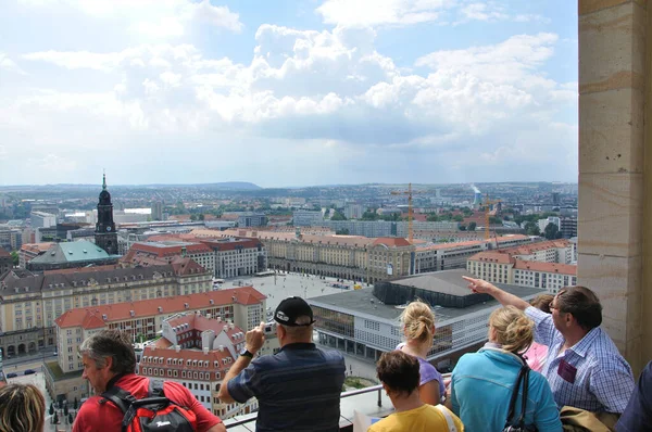 Dresden şehrinin merkezine yukarıdan bakan turistler güneş ışığı ve bulutlar