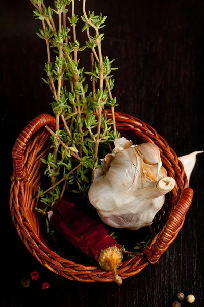 Basket with garlic, chili pepper and thyme — Stock Photo, Image