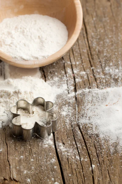 Wooden spoon with flour and cookie cutter — Stock Photo, Image