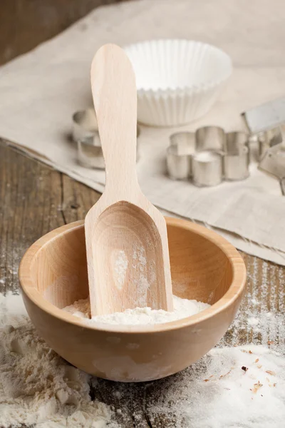 Cucchiaio di legno con farina e tagliabiscotti — Foto Stock