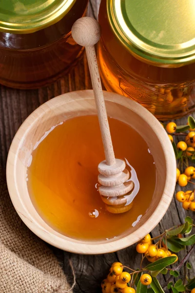 Pots and bowl with honey and berries — Stock Photo, Image