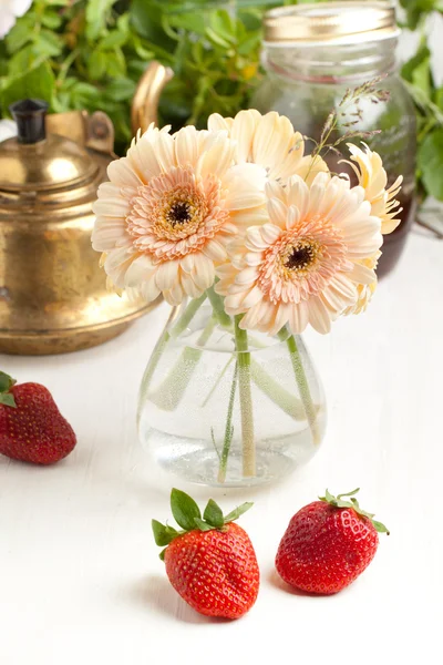 Bunch of gerbera flower with plate of strawberries — Stock Photo, Image