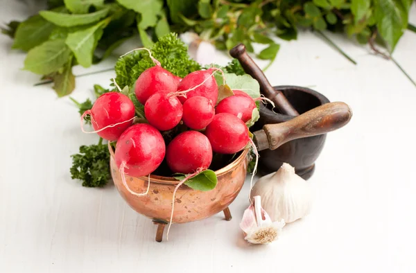 Fresh radishes with garlic and mortar — Stock Photo, Image