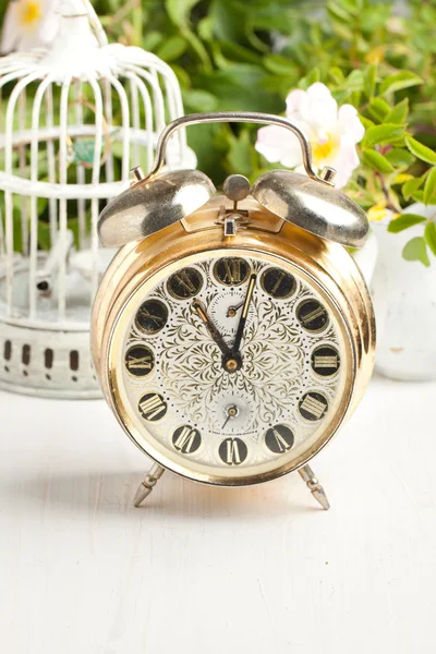 Old alarm-clock and vintage cage — Stock Photo, Image