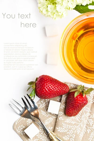 Cup of tea and strawberries over white — Stock Photo, Image
