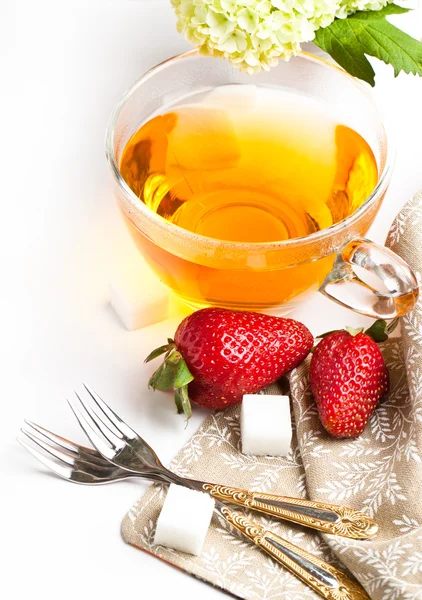 Cup of tea and strawberries over white — Stock Photo, Image